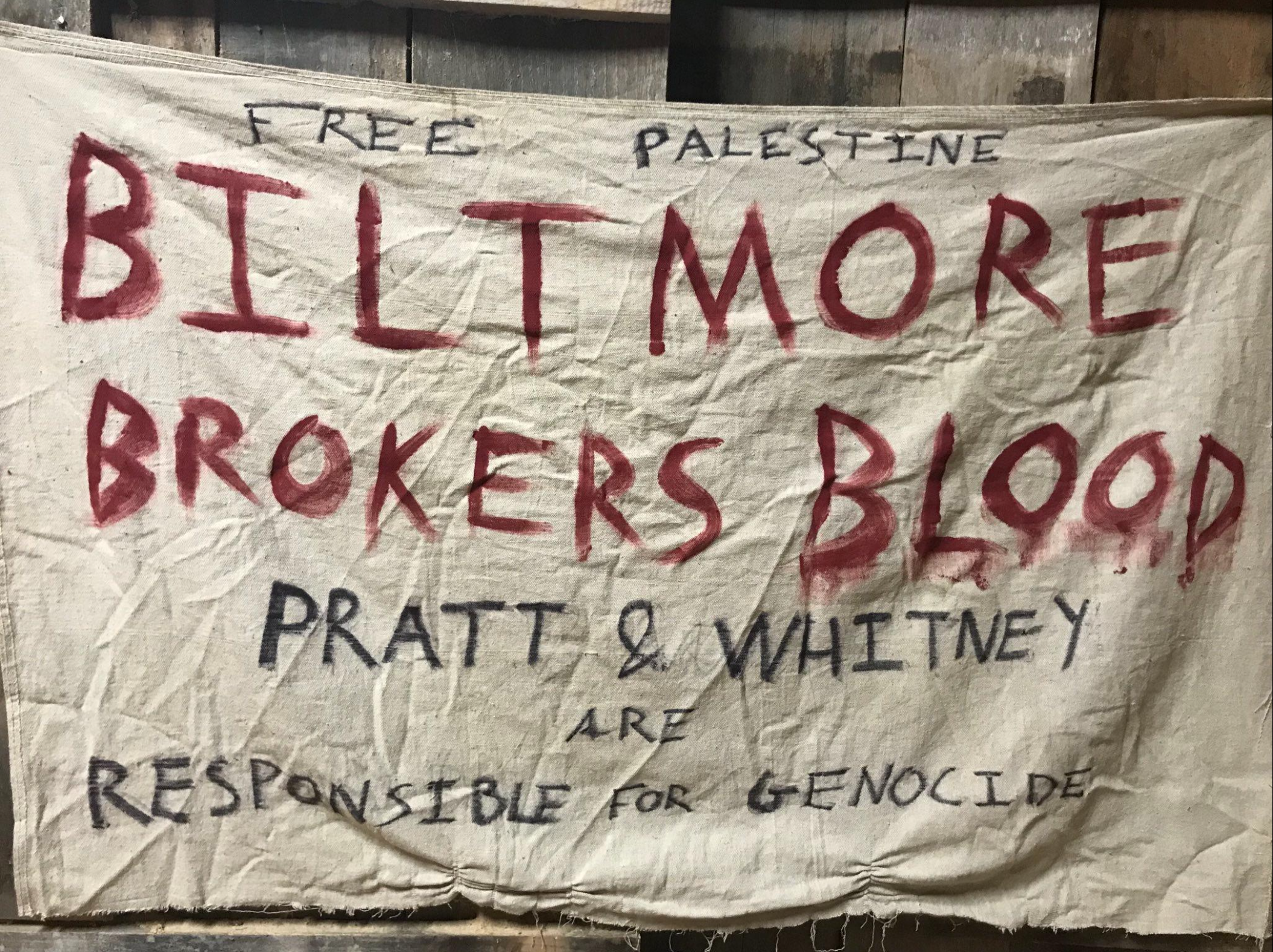 A banner with text "Free Palestine, Biltmore Brokers Blood, Pratt & Whitney are Responsible for Genocide"